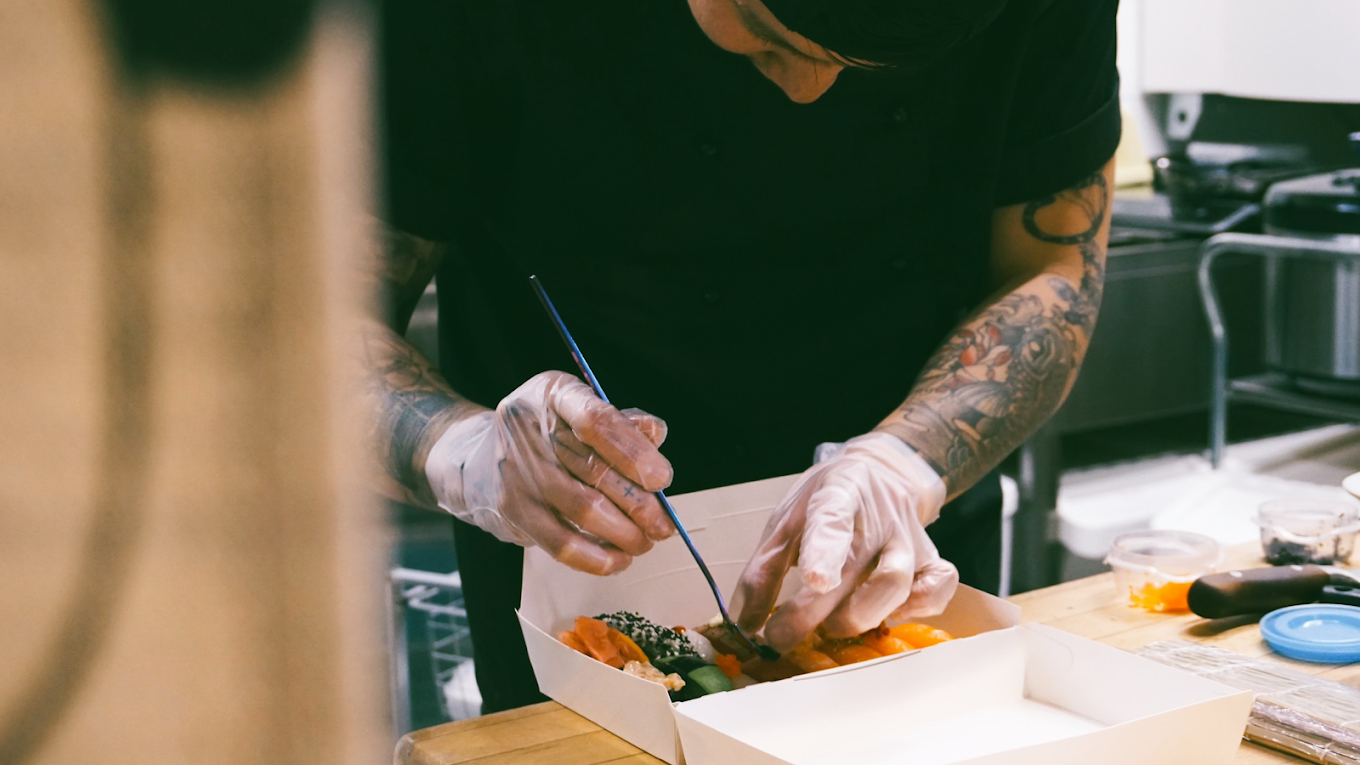Kock som rullar sushi